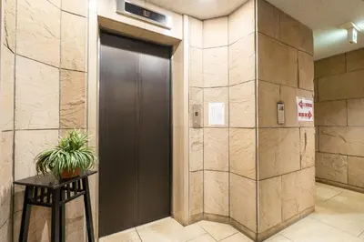 a brown door in a lobby with a potted plant at Tabist Hotel Mercury Asakusabashi in Tokyo