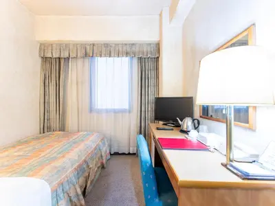 a hotel room with a bed and a desk with a computer at Tabist Hotel Mercury Asakusabashi in Tokyo