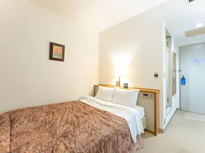 a hotel room with a bed with a white bedspread at Tabist Hotel Mercury Asakusabashi in Tokyo