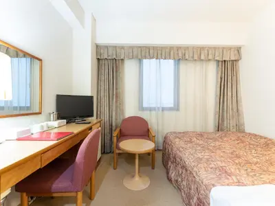 a hotel room with a bed and a desk with a computer at Tabist Hotel Mercury Asakusabashi in Tokyo