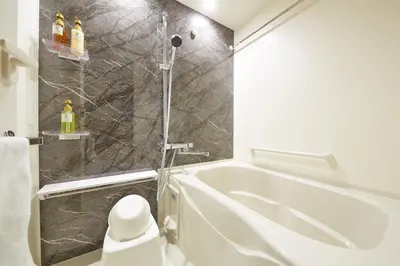 a bathroom with a shower and a white tub at MONday Apart Premium AKIHABARA ASAKUSABASHI Sta. in Tokyo