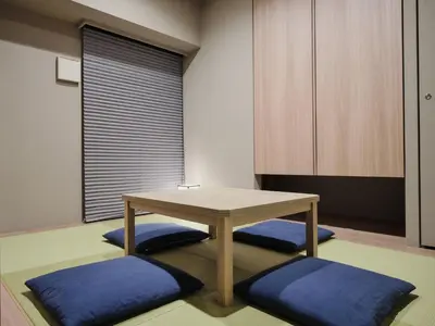 a room with a table and some blue cushions at MONday Apart Premium AKIHABARA in Tokyo