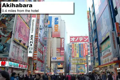 a crowd of people walking in a city with buildings at MONday Apart Premium AKIHABARA in Tokyo