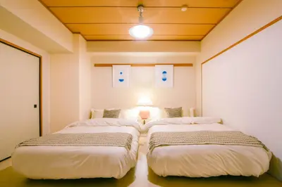 two beds in a small room with at Meee Kameari in Tokyo