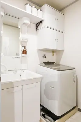 a white bathroom with a sink and a mirror at Meee Kameari in Tokyo
