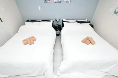 two beds in a room with teddy bears on them at LacQuer House ASAKUSAⅠ in Tokyo
