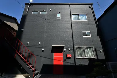 a building with a red door on the side of it at LacQuer House ASAKUSAⅠ in Tokyo