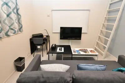 a living room with a couch and a table and a screen at LacQuer House ASAKUSAⅠ in Tokyo