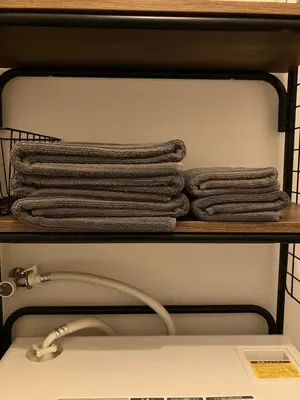 a pile of towels on a shelf above a sink at HOTEL THE SPACE in Tokyo