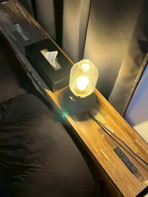 a small lamp on a table on a bed at HOTEL THE SPACE in Tokyo