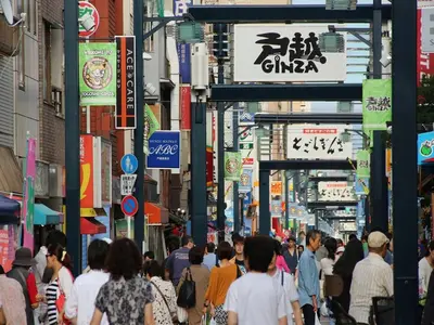 a crowd of people walking down a busy city street at APA Hotel Shinagawa Togoshi Ekimae in Tokyo