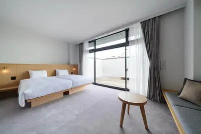a bedroom with a bed and a table and a couch at MUSTARD HOTEL SHIMOKITAZAWA in Tokyo