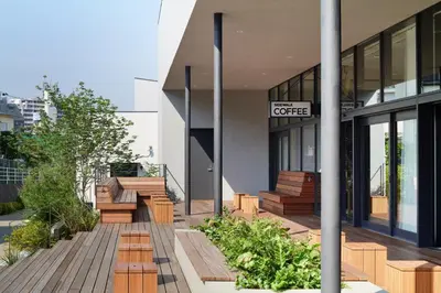 a building with wooden benches in front of a building at MUSTARD HOTEL SHIMOKITAZAWA in Tokyo