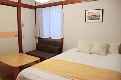 a small room with a bed and a chair at NAVI Azabujuban in Tokyo