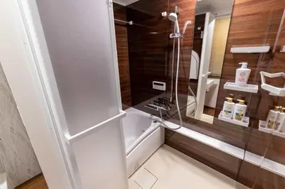 a shower with a glass door in a bathroom at Futaba Hotel in Tokyo