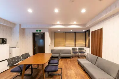 a room with a table and chairs and a couch at Futaba Hotel in Tokyo