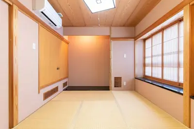an empty room with a large window and a hallway at Futaba Hotel in Tokyo