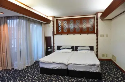 a bedroom with a bed and a large window at Futaba Hotel in Tokyo