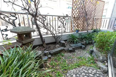 a garden with a bench and a fence at Futaba Hotel in Tokyo