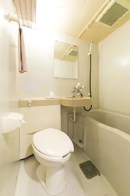 a bathroom with a toilet and a sink and a tub at Hotel Ohedo in Tokyo