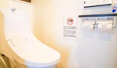 a bathroom with a toilet with a sign on the wall at Japanese Modern House in Shinagawa in Tokyo