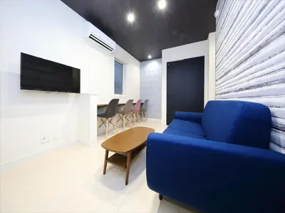 a living room with a blue couch and a table at COTO Tokyo Koenji in Tokyo