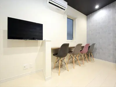 a room with a table with chairs and a flat screen tv at COTO Tokyo Koenji in Tokyo