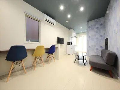 a living room with chairs and a table and a window at COTO Tokyo Koenji in Tokyo