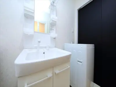 a white bathroom with a sink and a mirror at COTO Tokyo Koenji in Tokyo