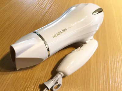 a white hair dryer sitting on a wooden table at Chill Inn Honan by Tranova in Tokyo