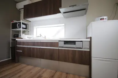 a kitchen with a white refrigerator and wooden cabinets at Sumida Base in Tokyo