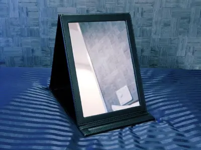 a black picture frame sitting on a bed at HOTEL LiVEMAX Ikebukuro Ekimae in Tokyo
