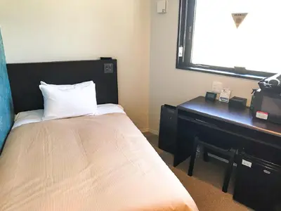 a bedroom with a bed with a desk and a piano at HOTEL LiVEMAX Ikebukuro Ekimae in Tokyo