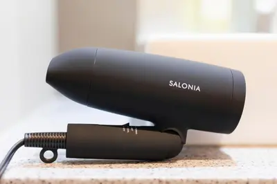 a black blow dryer sitting on a counter at HOTEL ASYL TOKYO KAMATA in Tokyo