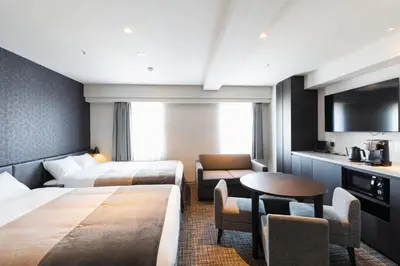 a hotel room with two beds and a table and chairs at HOTEL ASYL TOKYO KAMATA in Tokyo