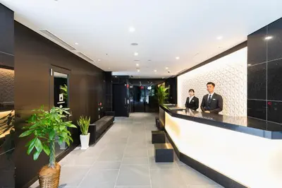 two men in suits sitting at a bar in a hotel lobby at HOTEL ASYL TOKYO KAMATA in Tokyo