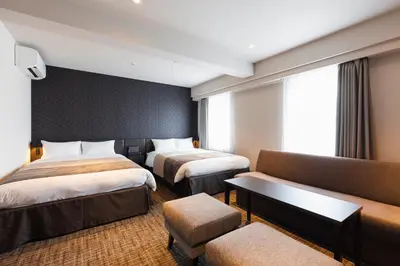 a hotel room with two beds and a couch at HOTEL ASYL TOKYO KAMATA in Tokyo