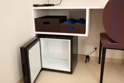 a small refrigerator with its door open next to a table at Mutsumi Building - Vacation STAY 00543v in Tokyo