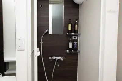 a bathroom with a shower with wine bottles on the wall at Mutsumi Building - Vacation STAY 00543v in Tokyo