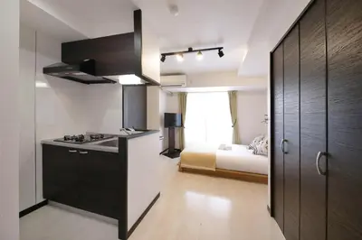 a kitchen with a stove and a bed in a room at Green Sea Oshiage in Tokyo