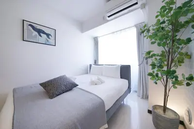 a bedroom with a bed and a potted plant at Green Sea Oshiage in Tokyo