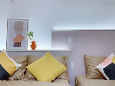 a living room with a couch with pillows on it at nestay apartment tokyo ginza in Tokyo