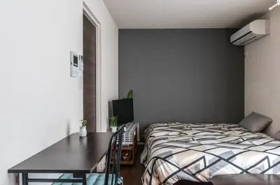 a bedroom with a bed and a table and a desk at Shibuya \u6e0b\u8c37 \u4e0b\u5317\u6ca2\u30a8\u30ea\u30a2 \u96fb\u52d5\u30ad\u30c3\u30af\u30dc\u30fc\u30c9LUUP\u6577\u5730\u5185 \u99c5\u5f92\u6b693\u5206 in Tokyo