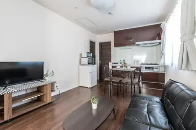a living room with a couch and a table at Shibuya \u6e0b\u8c37 \u4e0b\u5317\u6ca2\u30a8\u30ea\u30a2 \u96fb\u52d5\u30ad\u30c3\u30af\u30dc\u30fc\u30c9LUUP\u6577\u5730\u5185 \u99c5\u5f92\u6b693\u5206 in Tokyo