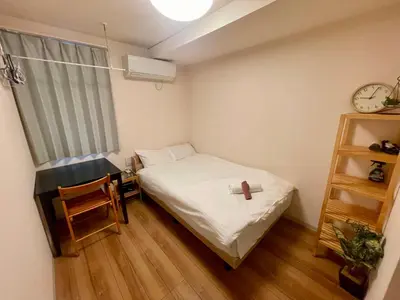 a small bedroom with a bed and a clock at Uhome Kamiitabashi Apartment in Tokyo
