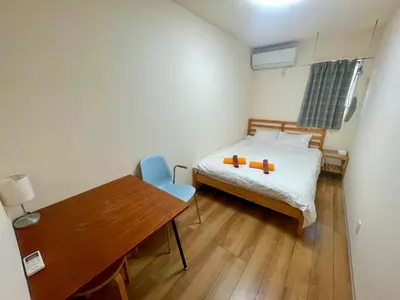 a small room with a bed and a wooden table at Uhome Kamiitabashi Apartment in Tokyo