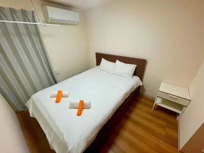 a bedroom with a bed with two towels on it at Uhome Kamiitabashi Apartment in Tokyo