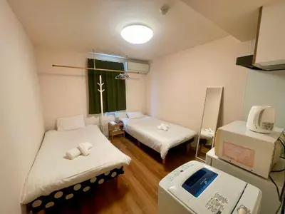a hospital room with two beds and a scale at Uhome Kamiitabashi Apartment in Tokyo