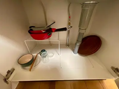 a kitchen with a shelf with a mortar and pestle and a pot at Uhome Kamiitabashi Apartment in Tokyo