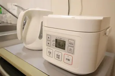 a white microwave sitting on a counter in a kitchen at Uhome Kamiitabashi Apartment in Tokyo
